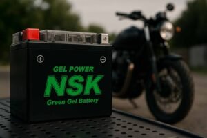 Batería de gel NSK Green Gel Battery en taller con motocicleta al fondo
